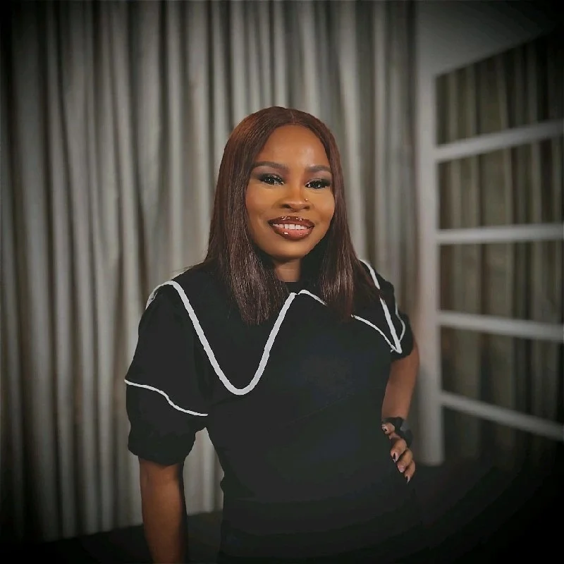 Yewande Adekoya, seated, smiling towards the camera